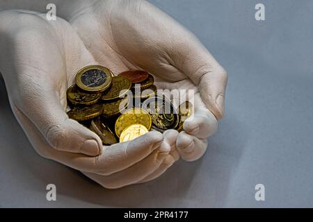 Zeigt viele verschiedene Münzen in der offenen Hand in Euro Währung Stockfoto