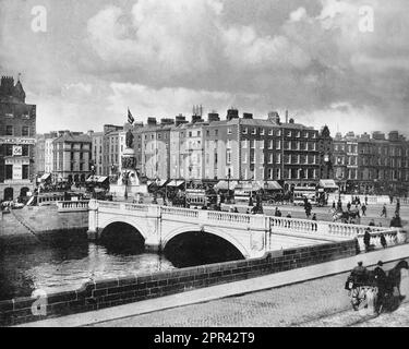 Ein Foto aus dem späten 19. Jahrhundert von der geschäftigen O'Connell Bridge, die den Fluss Liffey in Dublin, Irland überquert. Die ursprüngliche Brücke (die nach dem damaligen Lord Lieutenant von Irland, Frederick Howard, 5. Earl of Carlisle, benannt wurde) wurde von James Gandon entworfen und zwischen 1791 und 1794 erbaut. Die Brücke wurde zwischen 1877 und 1880 rekonstruiert und erweitert. Stockfoto