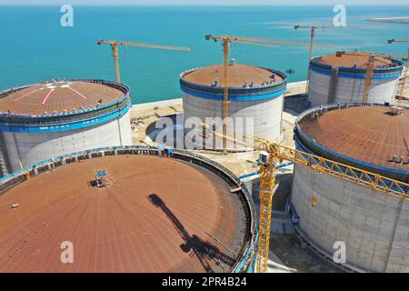 YANTAI, CHINA - 26. APRIL 2023 - ein LNG-Tank wird an der Baustelle einer LNG-Auffangstation im Gebiet Xigang im Hafen von Yantai, Shando, angehoben Stockfoto