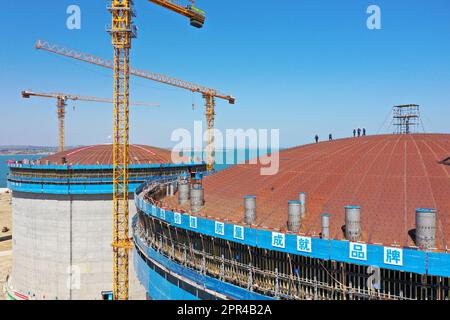 YANTAI, CHINA - 26. APRIL 2023 - ein LNG-Tank wird an der Baustelle einer LNG-Auffangstation im Gebiet Xigang im Hafen von Yantai, Shando, angehoben Stockfoto