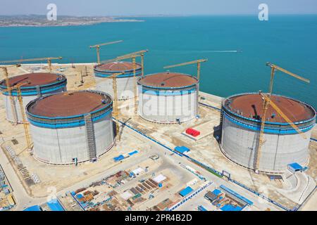 YANTAI, CHINA - 26. APRIL 2023 - ein LNG-Tank wird an der Baustelle einer LNG-Auffangstation im Gebiet Xigang im Hafen von Yantai, Shando, angehoben Stockfoto