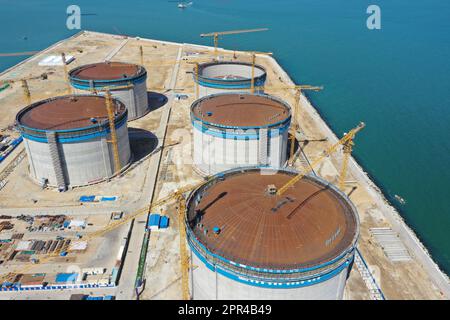 YANTAI, CHINA - 26. APRIL 2023 - ein LNG-Tank wird an der Baustelle einer LNG-Auffangstation im Gebiet Xigang im Hafen von Yantai, Shando, angehoben Stockfoto