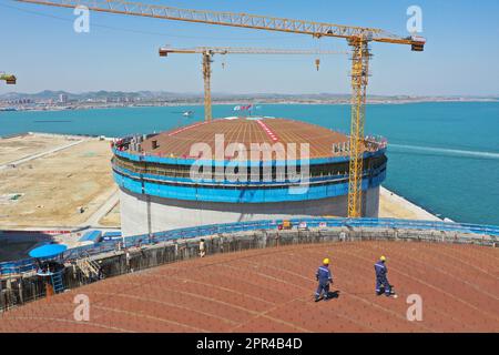 YANTAI, CHINA - 26. APRIL 2023 - ein LNG-Tank wird an der Baustelle einer LNG-Auffangstation im Gebiet Xigang im Hafen von Yantai, Shando, angehoben Stockfoto