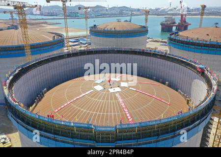 YANTAI, CHINA - 26. APRIL 2023 - ein LNG-Tank wird an der Baustelle einer LNG-Auffangstation im Gebiet Xigang im Hafen von Yantai, Shando, angehoben Stockfoto