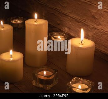 Foto von vielen Kerzen nebeneinander auf dem Tisch Stockfoto