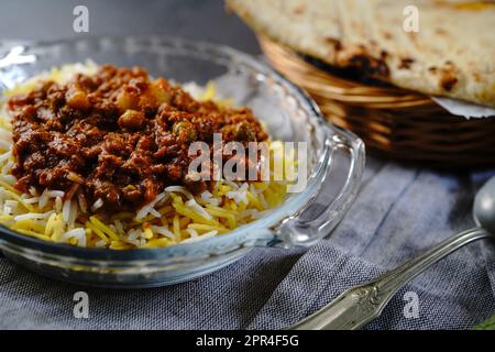 Koreshte Goosht – Persischer Rindfleischeintopf mit grünen Erbsenkartoffeln, serviert Basmati-Reis und Lavaschenbrot Stockfoto