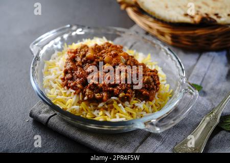 Koreshte Goosht – Persischer Rindfleischeintopf mit grünen Erbsenkartoffeln, serviert Basmati-Reis und Lavaschenbrot Stockfoto