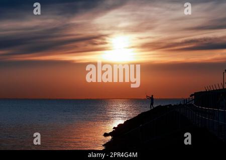 Melbourne, Australien. 26. April 2023. Ein einheimischer Fischer auf den Felsen am Middle Brighton Pier in Melbourne. Kredit: SOPA Images Limited/Alamy Live News Stockfoto