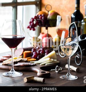 Ein Arrangement mit Rot-, Weiß- und Rosenwein, serviert mit Wurstplatte. Stockfoto