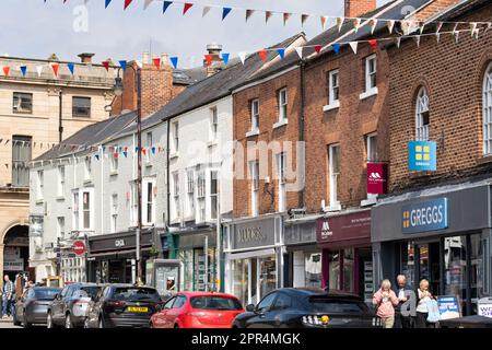 Einkäufer und Besucher von Welshpool - einer walisischen Marktstadt - gehen entlang der Broad Street, wo es verschiedene Geschäfte und Geschäfte gibt, Powys, Wales Stockfoto