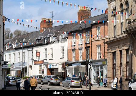 Einkäufer und Besucher von Welshpool - einer walisischen Marktstadt - gehen entlang der Broad Street, wo es verschiedene Geschäfte und Geschäfte gibt, Powys, Wales Stockfoto