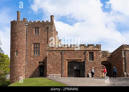 Menschen betreten den äußeren Eingang zum Powis Castle, eine zum 1. Weltkulturerbe gehörende mittelalterliche Festung aus Sandstein und Landhaus in der Nähe von Welshpool, Wales Stockfoto