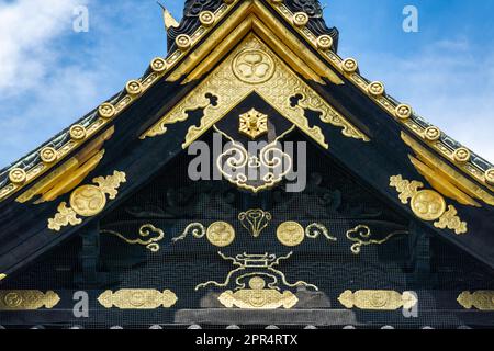 Details zu den kunstvoll verzierten goldenen Elementen auf dem Dachgipfel des Ueno Tosho-gu-Schreins im Ueno Park, Tokio, Japan. Der Schrein wurde 1627 erbaut und gilt als großartiges Beispiel für die Shinto-Architektur aus der Edo-Zeit. Stockfoto