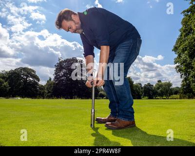 BICESTER, ENGLAND - 11. AUGUST 2021: David Hedges-Gower von Modern Lawn Care testet den Boden auf einem privaten Grundstück in Oxfordshire. Stockfoto