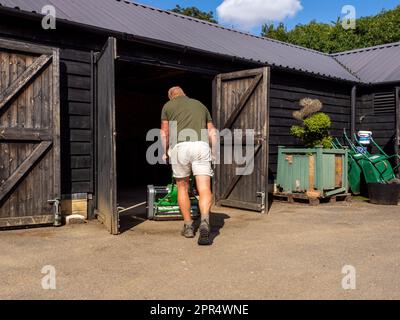 BICESTER, ENGLAND - 11. AUGUST 2021: Paul Gough, Chefgärtner auf einem Privatgrundstück in Oxfordshire, mit Maschinen. Stockfoto