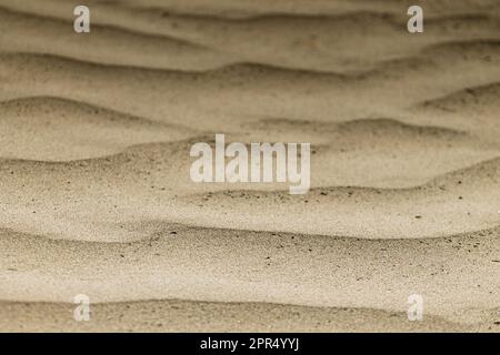 Eine Strandküste mit einem Wellenmuster im Sand Stockfoto