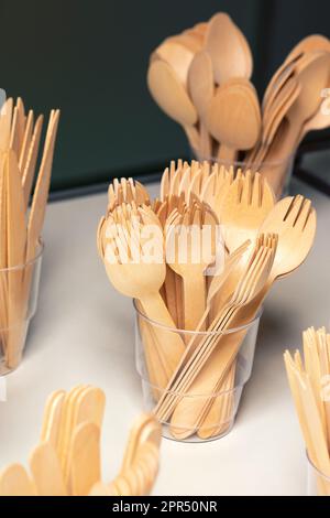 Umweltfreundliche Einweg-Küchenutensilien. Abgerundete Holzgabeln in einem Kunststoffbecher. Ökologie, Null-Abfall-Konzept. Stockfoto