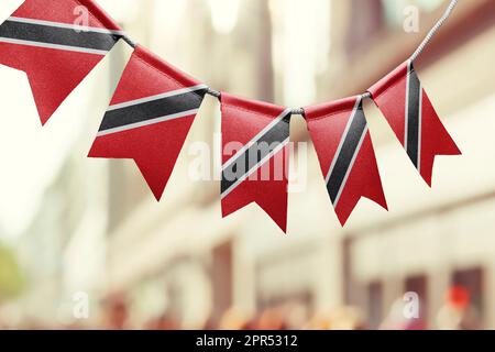 Eine Girlande mit Nationalflaggen Trinidad und Tobago auf abstraktem, verschwommenem Hintergrund. Stockfoto