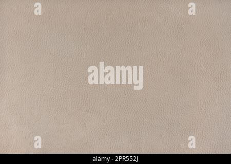 Texturhintergrund aus beigefarbenem Velours, das wie eine Lederoberfläche strukturiert ist. Textilstruktur Nahaufnahme Polstermöbel Textilmaterial Design innen Stockfoto