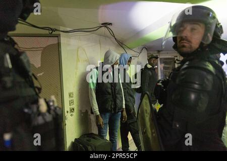 Seine Saint Denis, Frankreich. 26. April 2023. Mehrere Flüchtlinge umgeben von Polizisten. Evakuierung des Unibeton-Squat auf der Ile-Saint-Denis: Fast 400 Menschen im Exil, versorgt am 26. april 2023 in Paris. Foto: Christophe Michel/ABACAPRESS.COM Kredit: Abaca Press/Alamy Live News Stockfoto