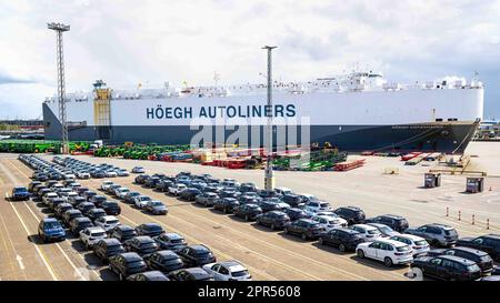 Bremerhaven, Deutschland. 26. April 2023. Die Autos stehen vor dem Autotransporter „Hoegh Copenhagen“ auf dem Gelände des BLG Autoterminals Bremerhaven. Der Seehafen- und Logistikdienstleister BLG mit Sitz in Bremen hat im vergangenen Jahr trotz zahlreicher Krisen seine Umsätze und Gewinne gesteigert. Kredit: Sina Schuldt/dpa/Alamy Live News Stockfoto