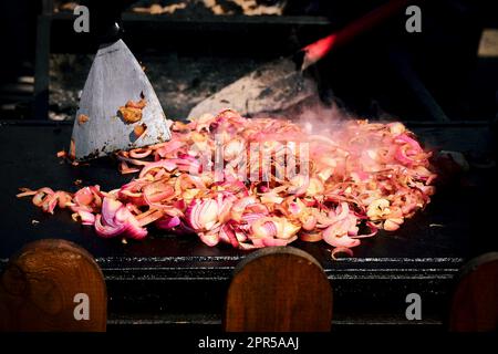 Gegrillte rote Zwiebelscheiben verleihen jedem Grillgericht einen Hauch süßen und rauchigen Aromas. Stockfoto