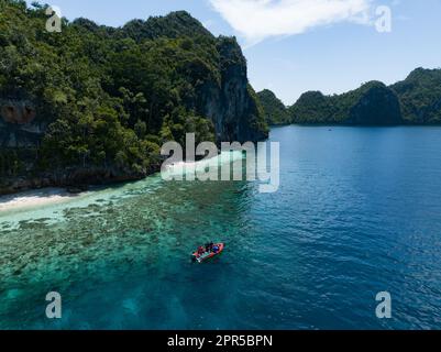 Wunderschöne und vielfältige Korallenriffe umgeben die dramatischen Kalksteininseln, die sich aus Raja Ampats vielfältiger Meereslandschaft erheben. Stockfoto