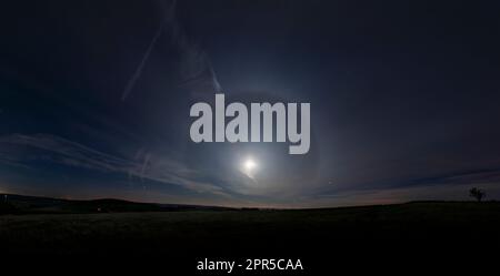 Halo um den Mond von einem nächtlichen Spaziergang im Peak District. Ein 22°-Heiligenschein, wie die Eiskristalle in der Erdatmosphäre brechen und das Mondlicht reflektieren Stockfoto