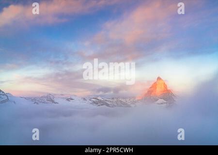 Wolken über dem Matterhorn-Gipfel, der bei Sonnenaufgang aus dem Nebel austritt, Gornergrat, Zermatt, Kanton Wallis, Schweiz Stockfoto