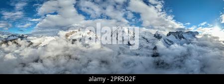 Panoramablick aus der Vogelperspektive auf den schneebedeckten Monte Rosa, Lyskamm, Pollux, Castor, Breithorn in einem Wolkenmeer, Zermatt, Wallis, Schweiz Stockfoto