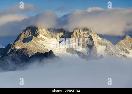 Wolken über dem Ober Gabelhorn und den Wellenkuppe Berggipfeln bei einem nebligen Sonnenaufgang, Gornergrat, Zermatt, Kanton Valais, Schweiz Stockfoto