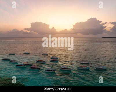 Boote im kristallklaren Meer bei Sonnenuntergang, Sansibar, Tansania Stockfoto