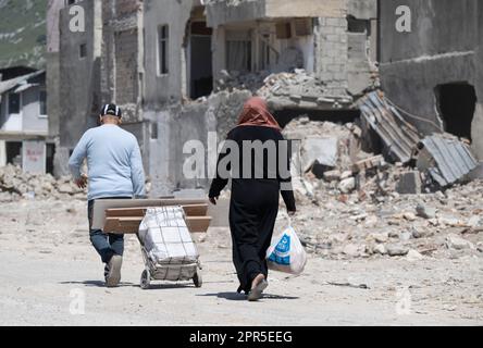 Antakya, Türkei. 26. April 2023. Die Bewohner gehen vorbei an Ruinen in den Trümmern der Altstadt von Antakya. Offiziellen Zahlen zufolge wurden beim Erdbeben im Februar 6 mehr als 50.000 Menschen getötet. Kredit: Boris Roessler/dpa/Alamy Live News Stockfoto