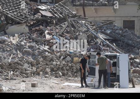 Antakya, Türkei. 26. April 2023. Persönliche Gegenstände wurden von zwei Männern in den Trümmern der Altstadt von Antakya in ihr Auto geladen. Offiziellen Zahlen zufolge wurden beim Erdbeben im Februar 6 mehr als 50.000 Menschen getötet. Kredit: Boris Roessler/dpa/Alamy Live News Stockfoto