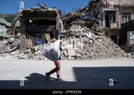 Antakya, Türkei. 26. April 2023. Ein Mädchen schleppt einen Sack in die Trümmer der alten Stadt Antakya. Offiziellen Zahlen zufolge wurden beim Erdbeben im Februar 6 mehr als 50.000 Menschen getötet. Kredit: Boris Roessler/dpa/Alamy Live News Stockfoto