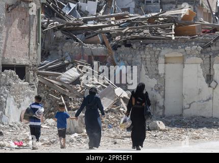 Antakya, Türkei. 26. April 2023. Zwei Frauen gehen mit ihren Kindern durch die Trümmer der Altstadt von Antakya. Offiziellen Zahlen zufolge wurden bei dem Beben am 6. Februar mehr als 50.000 Menschen getötet. Kredit: Boris Roessler/dpa/Alamy Live News Stockfoto