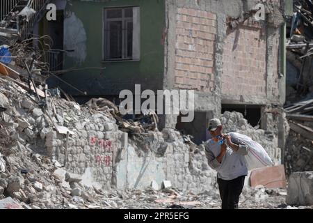 Antakya, Türkei. 26. April 2023. Ein Mann schleppt einen Sack durch die Trümmer der alten Stadt Antakya. Offiziellen Zahlen zufolge wurden bei dem Beben am 6. Februar mehr als 50.000 Menschen getötet. Kredit: Boris Roessler/dpa/Alamy Live News Stockfoto