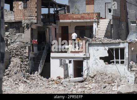 Antakya, Türkei. 26. April 2023. Menschen gehen in ein Haus, um persönliche Gegenstände in den Trümmern der Altstadt von Antakya zu holen. Nach offiziellen Zahlen starben beim Beben vom Februar 6 über 50.000 Menschen. Kredit: Boris Roessler/dpa/Alamy Live News Stockfoto