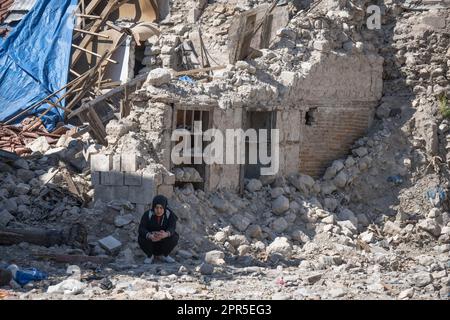 Antakya, Türkei. 26. April 2023. Eine Frau sitzt in den Trümmern der Altstadt von Antakya. Offiziellen Zahlen zufolge wurden bei dem Beben am 6. Februar mehr als 50.000 Menschen getötet. Kredit: Boris Roessler/dpa/Alamy Live News Stockfoto