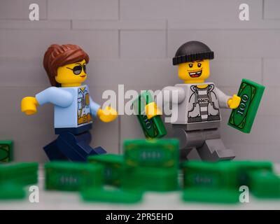 Tambov, Russische Föderation - 25. März 2023 Ein Lego-Dieb mit Geld, das vor einer Lego-Polizisten-Minifigure davonläuft Stockfoto