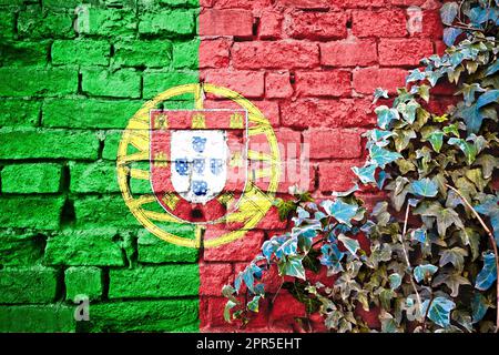 Portugals Grunge-Flagge an der Ziegelwand mit Efeu-Pflanze, Landessymbol-Konzept Stockfoto