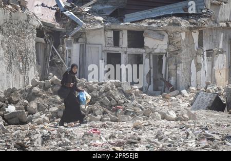 Antakya, Türkei. 26. April 2023. Eine Frau geht durch die Trümmer der Altstadt von Antakya. Offiziellen Zahlen zufolge wurden bei dem Beben am 6. Februar mehr als 50.000 Menschen getötet. Kredit: Boris Roessler/dpa/Alamy Live News Stockfoto