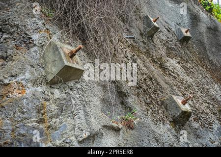 Felsanker und Anker zum Schutz der Hänge vor Zerstörung. Schutz des felsigen Gefälles vor dem Einsturz durch verstärkte Betonanker Stockfoto