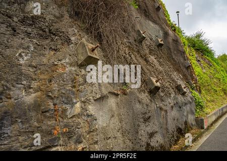 Felsanker und Anker zum Schutz der Hänge vor Zerstörung. Schutz des felsigen Gefälles vor dem Einsturz durch verstärkte Betonanker Stockfoto