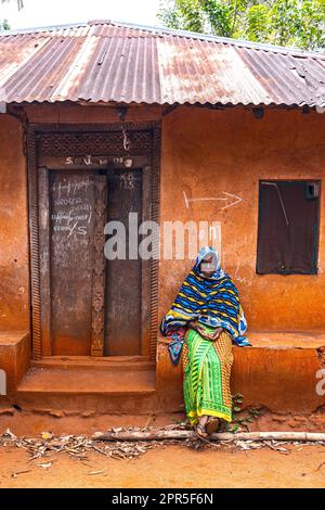 Porträt einer wunderschönen Frau, die sich aus dem traditionellen afrikanischen Haus Sansibar, Tansania, entspannt Stockfoto