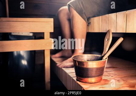 Sauna und Mann in Finnland. Dampfbad mit Whirlpool aus Holz. Finnische Sommerhütte oder Hotel. Person mit Handtuch. Heiße und gesunde Therapie für Menschen. Stockfoto