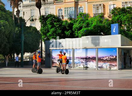 Eine Gruppe von Touristen, die Anweisungen zur Nutzung von zweirädrigen Elektrofahrzeugen mit dem segway vor dem Tourismusbüro der Stadt Malaga erhalten Stockfoto