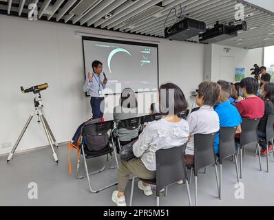 Dr. so Chu-Wing, der stellvertretende Kurator des Hong Kong Space Museum, spricht mit Astronomiefans im Aussichtsraum, der eingerichtet wurde, um die Sonnenfinsternis im Salisbury Park in Tsim Sha Tsui am 20. April 2023 zu beobachten. 20APR23 SCMP/Connor Mycroft Stockfoto