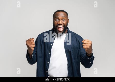 - Ja, Ich Weiß Äußerst zufriedener afroamerikanischer Mann, der seinen Sieg feiert, sich freut und ja-Geste, positive Emotionen zeigt. Studioaufnahmen im Innenbereich isoliert auf weißem Hintergrund Stockfoto