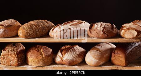 Köstliches Brot auf Holzregalen Stockfoto